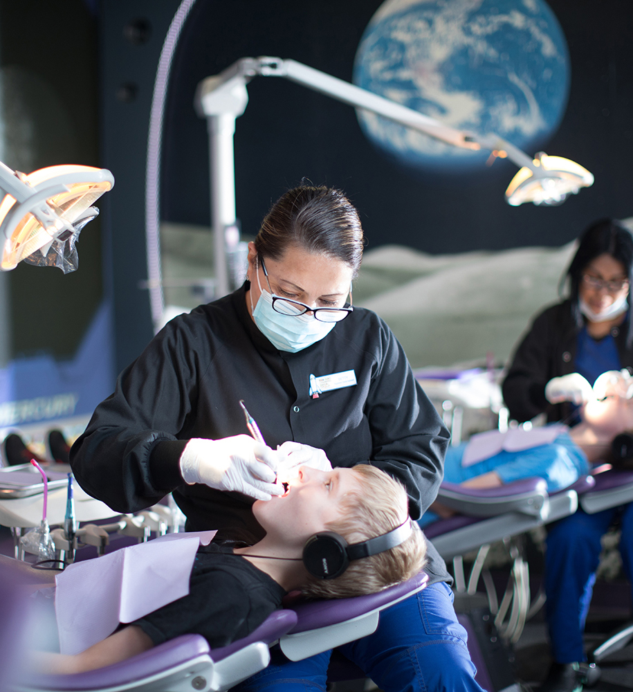 A group of dentists working on a child in a dental clinic.