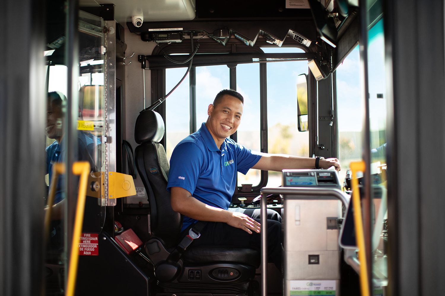 A man sitting in the driver's seat of a bus.